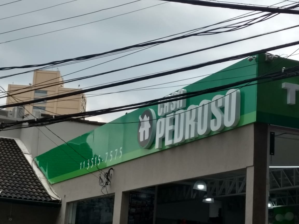Fachada em ACM verde com letras-caixa fixadas com fita dupla face